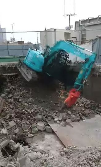ガラスロープ降下で転倒寸前の重機